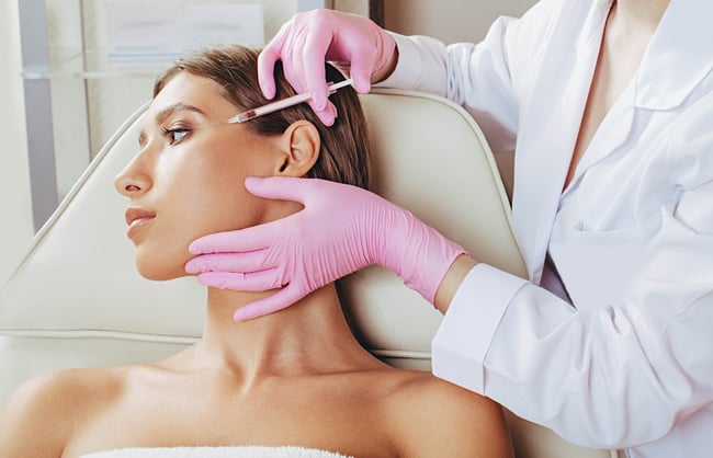 woman receiving injections from a cosmetic dermatologist