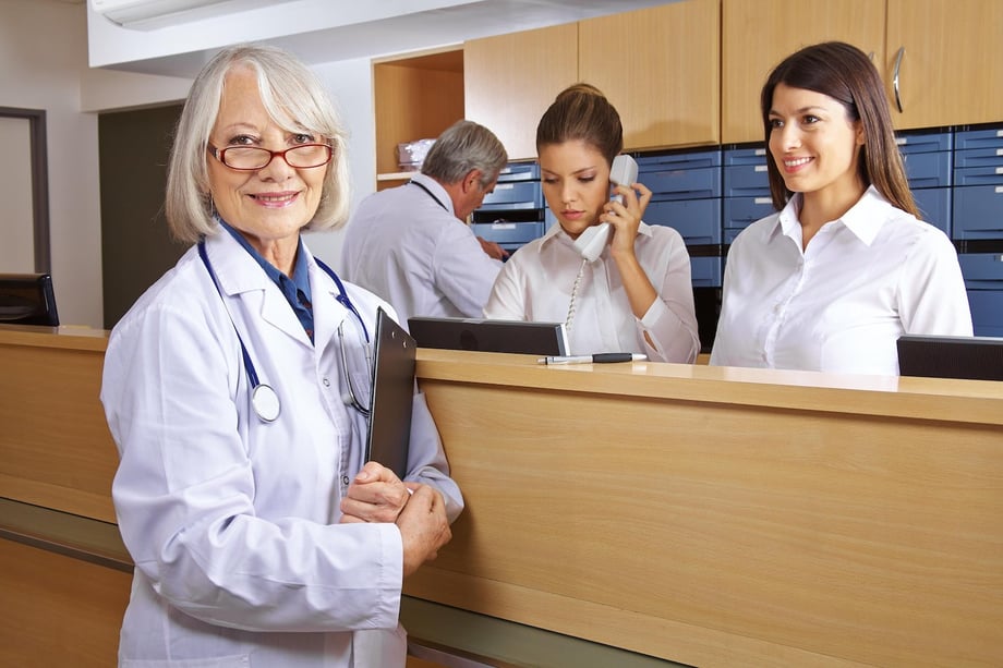 doctor standing in front of medical billing desk